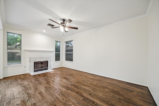 unfurnished living room with crown molding, a fireplace, a ceiling fan, and wood finished floors
