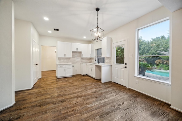 kitchen featuring decorative light fixtures, visible vents, tasteful backsplash, dark wood finished floors, and white cabinets