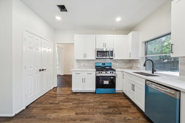 kitchen with visible vents, white cabinetry, a sink, dark wood finished floors, and appliances with stainless steel finishes