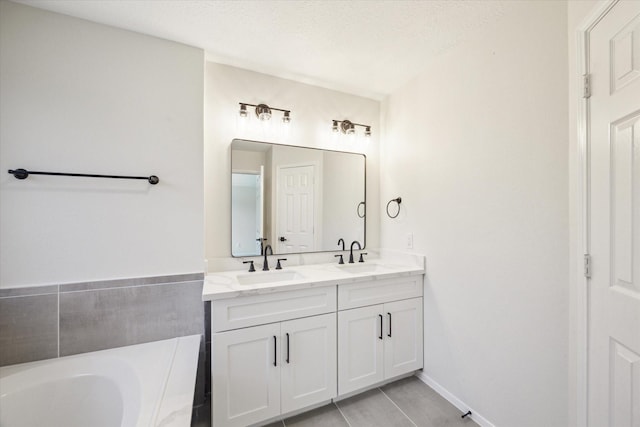 bathroom featuring double vanity, a sink, baseboards, and a washtub