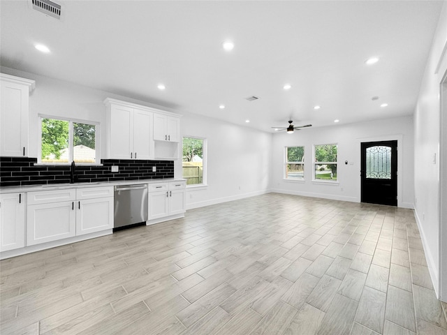 kitchen featuring tasteful backsplash, stainless steel dishwasher, visible vents, ceiling fan, and a wealth of natural light