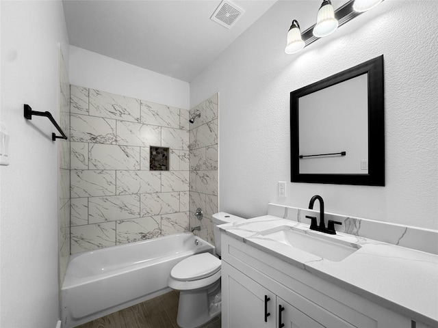 full bathroom with wood finished floors, toilet, vanity, visible vents, and washtub / shower combination