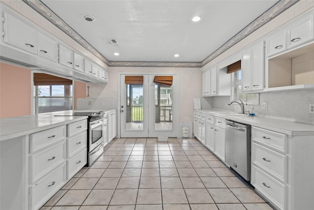 1114 Helen Dowdy Prt, Bolivar, TX 77650 - kitchen featuring stainless steel appliances, a sink, light countertops, white cabinets, and light tile patterned flooring