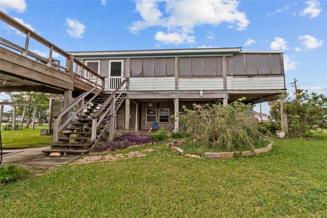 1114 Helen Dowdy Prt, Bolivar, TX 77650 - rear view of house featuring a sunroom, a yard, board and batten siding, and a wooden deck