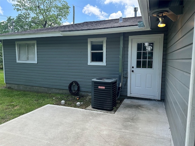 1402 Firwood Cir, Pasadena, TX 77502 - property entrance featuring cooling unit, a patio, and roof with shingles