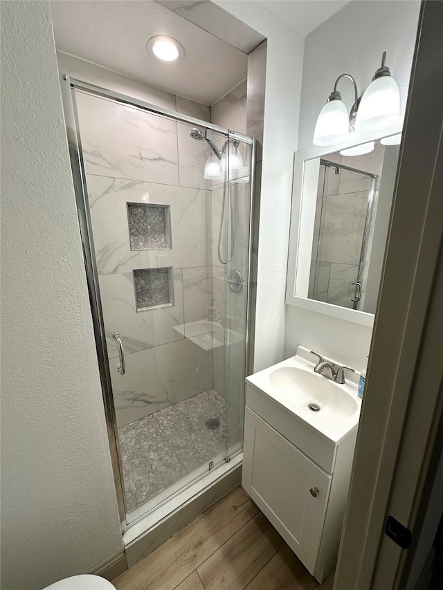 1402 Firwood Cir, Pasadena, TX 77502 - bathroom featuring a shower stall, wood finished floors, vanity, and toilet