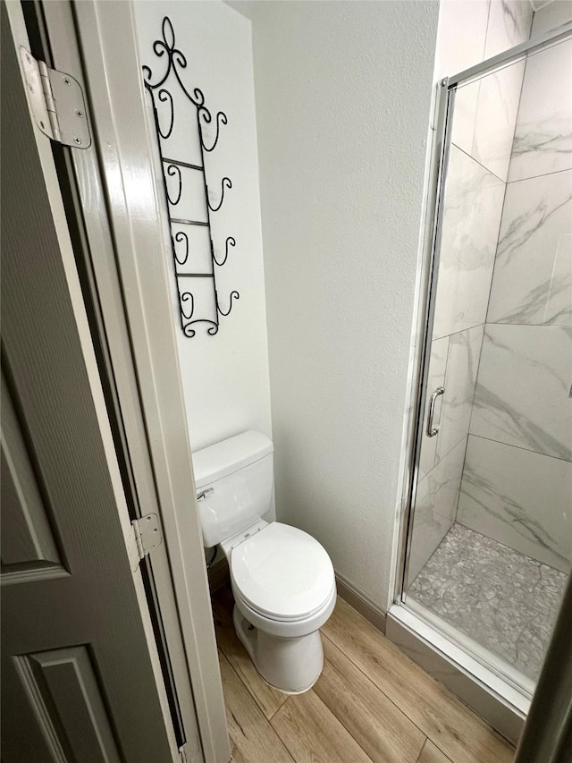 1402 Firwood Cir, Pasadena, TX 77502 - bathroom featuring a shower stall, wood finished floors, toilet, and baseboards