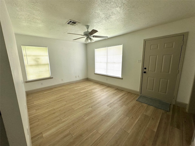 1402 Firwood Cir, Pasadena, TX 77502 - spare room with light wood-style floors, a ceiling fan, baseboards, and a textured ceiling