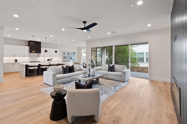 living area with ceiling fan, recessed lighting, and light wood finished floors