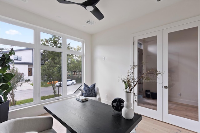 interior space with light wood-style flooring, french doors, a ceiling fan, and visible vents