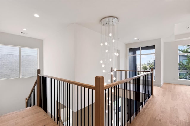 hall featuring an upstairs landing, wood finished floors, recessed lighting, and baseboards