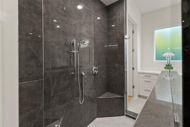 full bath with a tile shower and vanity