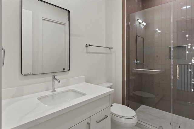 bathroom with vanity, toilet, and a stall shower