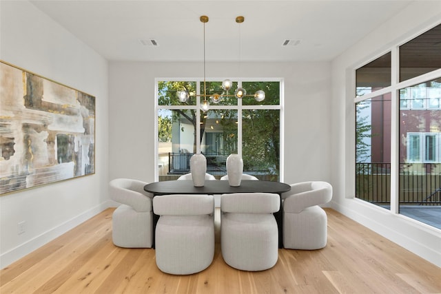 dining space featuring wood finished floors, visible vents, and baseboards