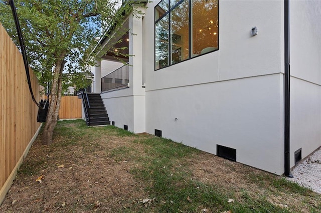 view of home's exterior featuring stairs, crawl space, and fence