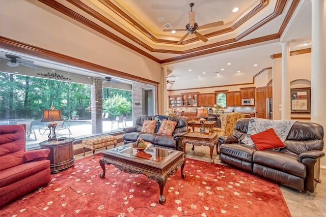 living area with decorative columns, ceiling fan, and crown molding