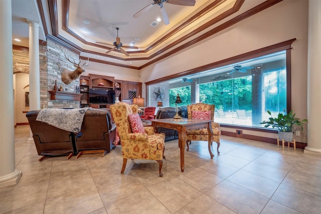 interior space featuring ceiling fan, decorative columns, and a tray ceiling