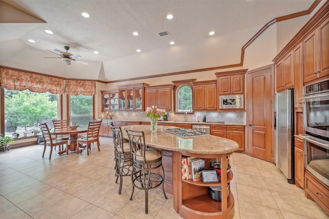 kitchen with open shelves, appliances with stainless steel finishes, decorative backsplash, and a sink