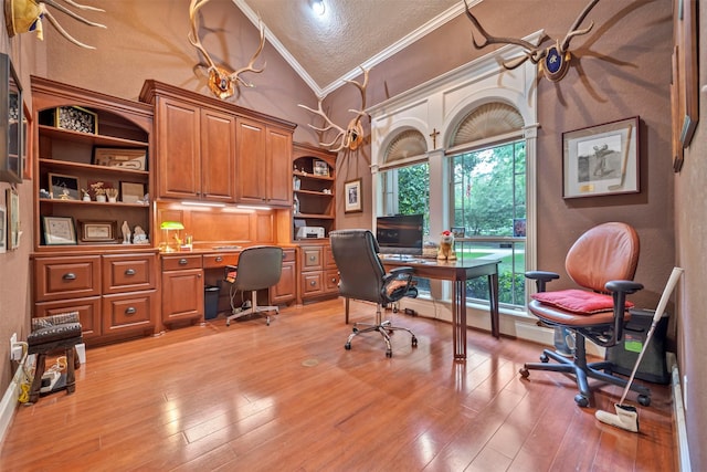 office featuring built in desk, high vaulted ceiling, light wood-style flooring, ornamental molding, and a textured ceiling
