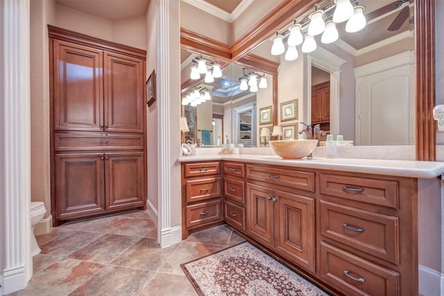 bathroom with toilet, vanity, and crown molding