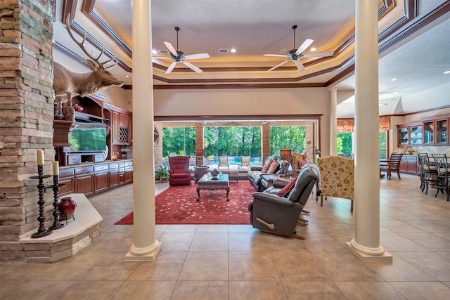 living room with crown molding, ceiling fan, decorative columns, and tile patterned floors