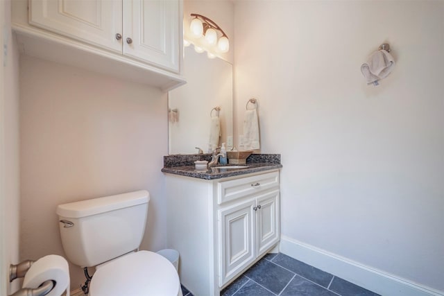 bathroom with toilet, tile patterned flooring, vanity, and baseboards