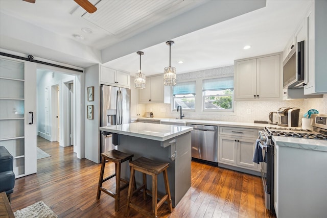 1343 Allston St, Houston, TX 77008 - kitchen with appliances with stainless steel finishes, a sink, a breakfast bar area, dark wood-type flooring, and backsplash