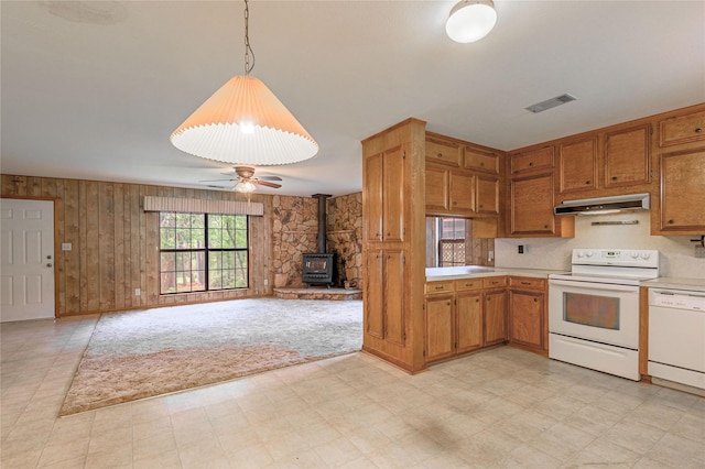 350 Shoreline Dr, Huntsville, TX 77320 - kitchen featuring a wood stove, under cabinet range hood, white appliances, visible vents, and light countertops