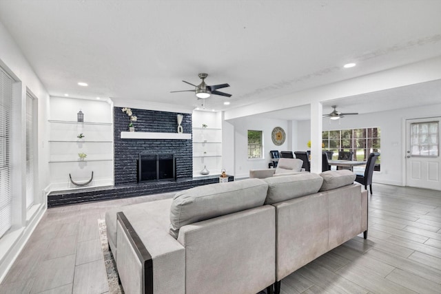 561 Brandon Rd, Conroe, TX 77302 - living room with recessed lighting, a brick fireplace, built in shelves, ceiling fan, and baseboards