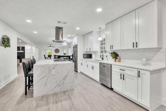 561 Brandon Rd, Conroe, TX 77302 - kitchen with a sink, appliances with stainless steel finishes, visible vents, a kitchen island, and recessed lighting