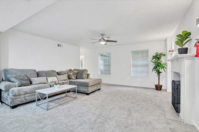 561 Brandon Rd, Conroe, TX 77302 - living room with light carpet, ceiling fan, a textured ceiling, and a fireplace