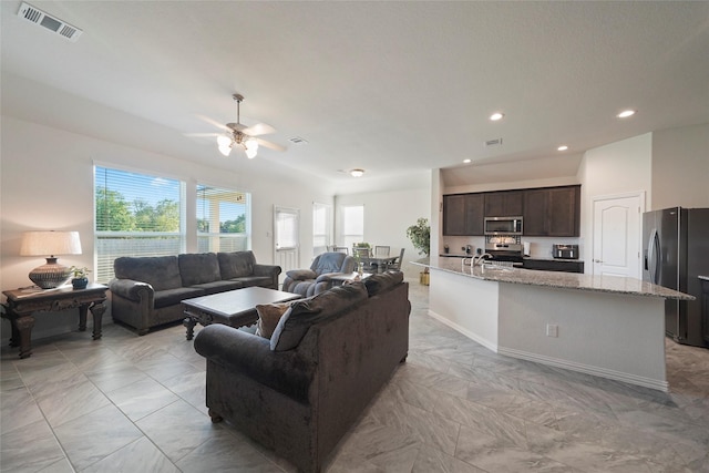 living area with visible vents, ceiling fan, recessed lighting, and marble finish floor