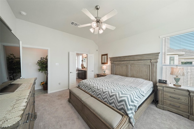bedroom with light carpet, ensuite bathroom, baseboards, visible vents, and lofted ceiling