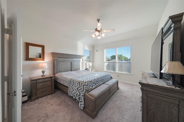 bedroom with a ceiling fan, light carpet, and baseboards