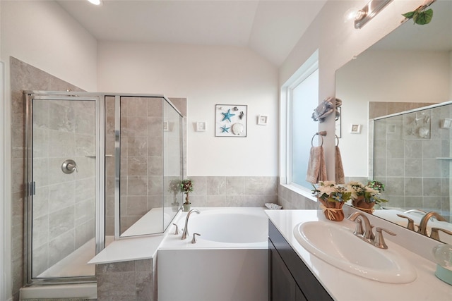 bathroom with a garden tub, a shower stall, vaulted ceiling, and vanity