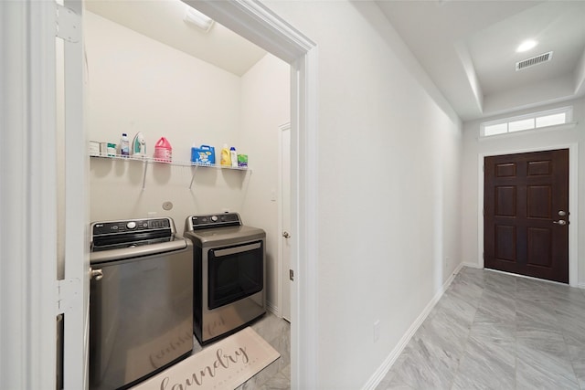 clothes washing area with visible vents, baseboards, laundry area, and washer and clothes dryer