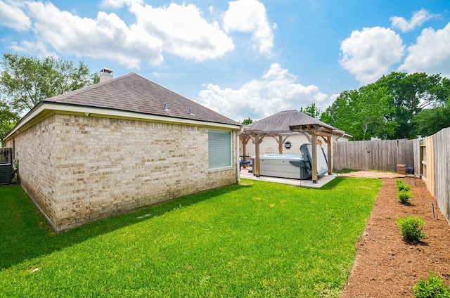 view of yard with a patio, a gazebo, a hot tub, central AC, and a fenced backyard