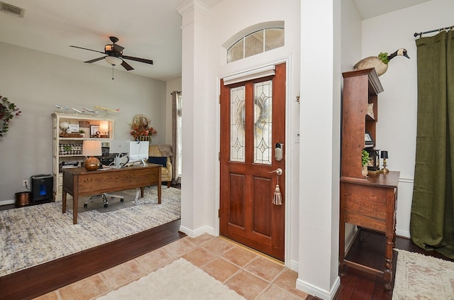 foyer featuring baseboards, visible vents, ceiling fan, and light wood finished floors