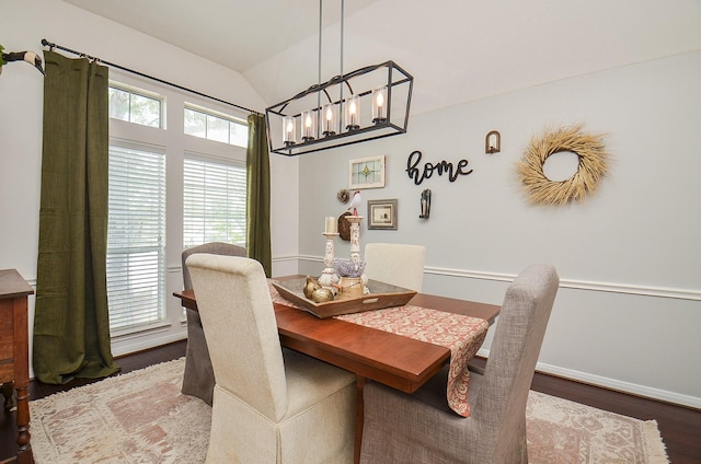 dining room featuring a notable chandelier, baseboards, vaulted ceiling, and dark wood-type flooring