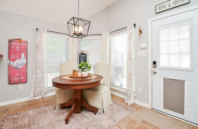 dining room featuring lofted ceiling, a notable chandelier, tile patterned floors, and baseboards