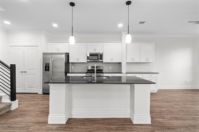 12975 Corona Ct, Willis, TX 77318 - kitchen with crown molding, stainless steel appliances, dark countertops, and a sink
