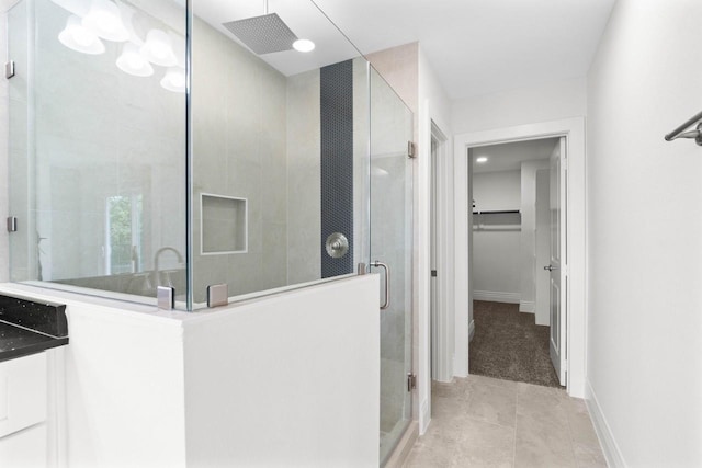12975 Corona Ct, Willis, TX 77318 - full bath featuring tile patterned floors, a spacious closet, a shower stall, and baseboards