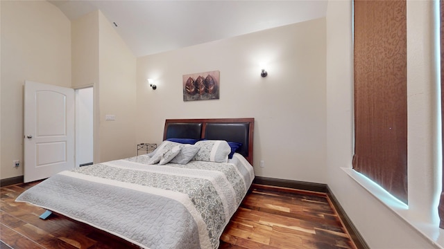 bedroom with high vaulted ceiling, wood finished floors, and baseboards