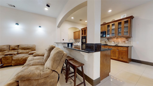 bar featuring recessed lighting, arched walkways, black appliances, backsplash, and visible vents