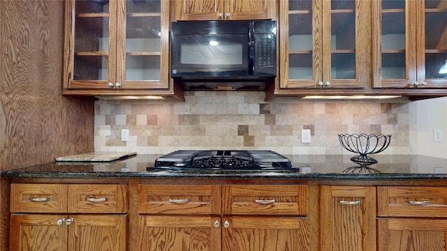 kitchen with black appliances, brown cabinets, decorative backsplash, and glass insert cabinets