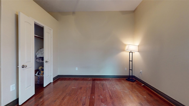 unfurnished bedroom with wood finished floors and baseboards