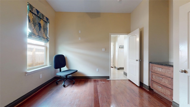 unfurnished room featuring dark wood-style floors and baseboards