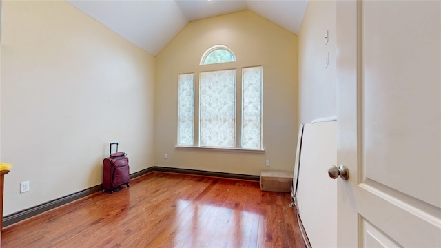empty room featuring wood finished floors and vaulted ceiling