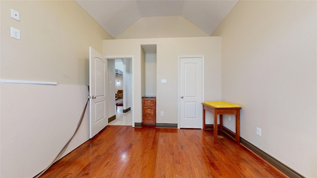 unfurnished bedroom featuring wood finished floors and vaulted ceiling