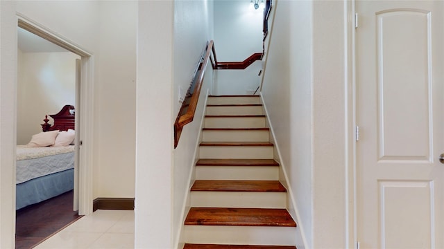 stairway featuring tile patterned flooring and baseboards